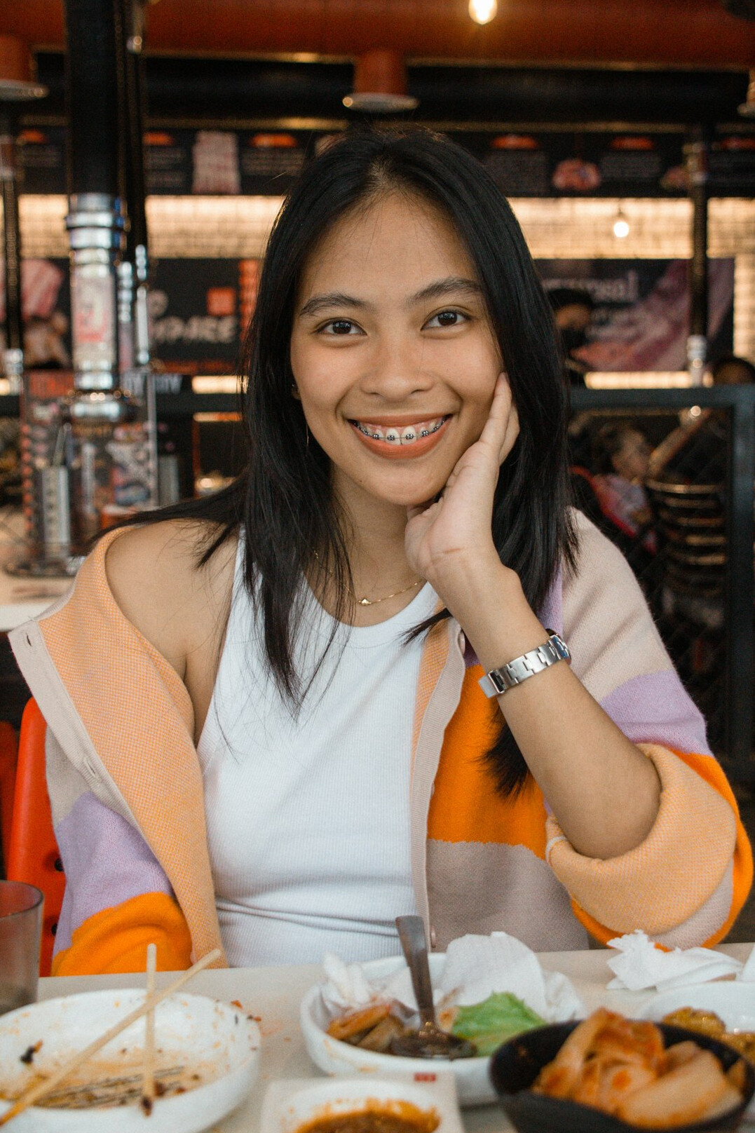 Smiling Chinese Singaporean woman in business casual attire holding a tablet