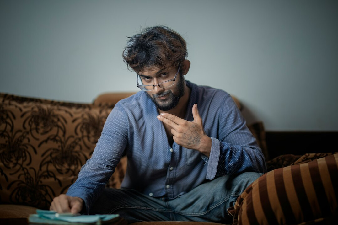 Indian Singaporean man reviewing insurance policy documents on a sofa
